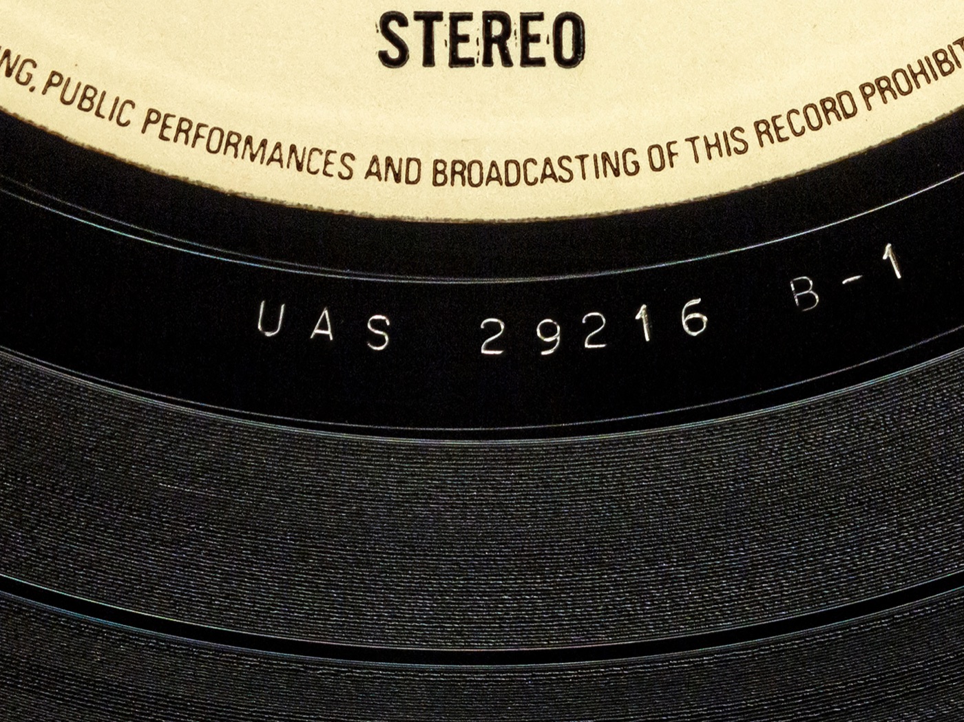Close-up of a record's runout area showing the matrix code etched between the last groove and the label